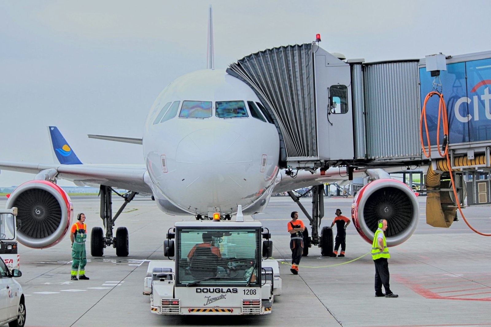 Airliner at the gate with a jet bridge and ground crew